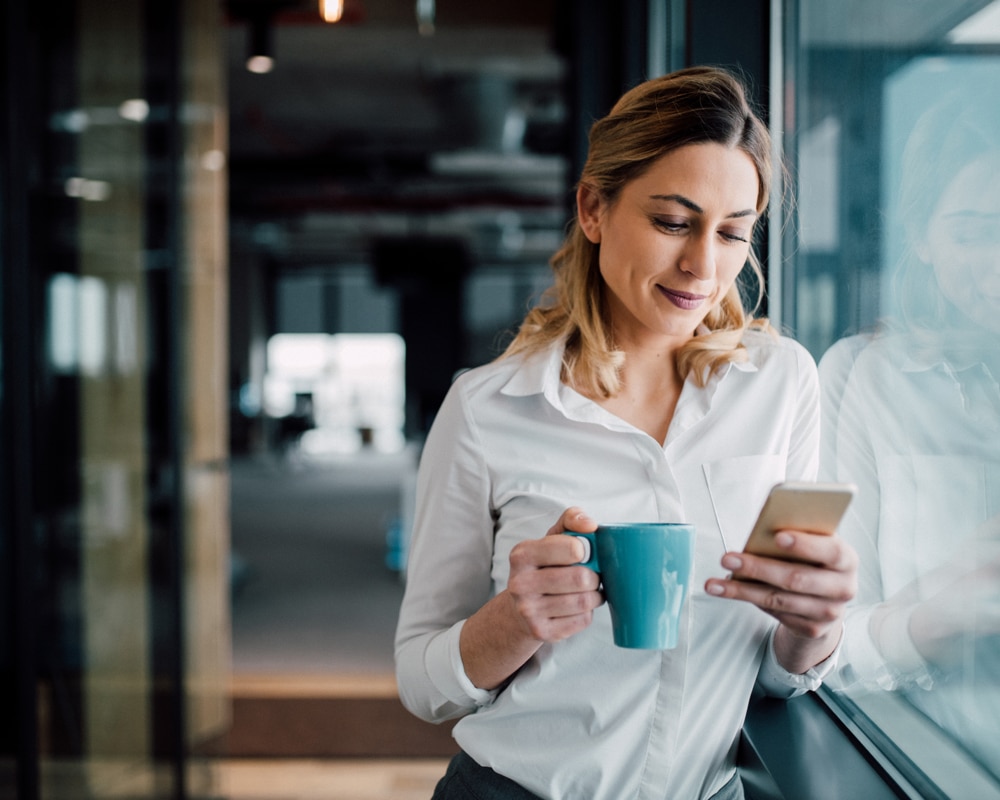 Woman with phone and coffee mug