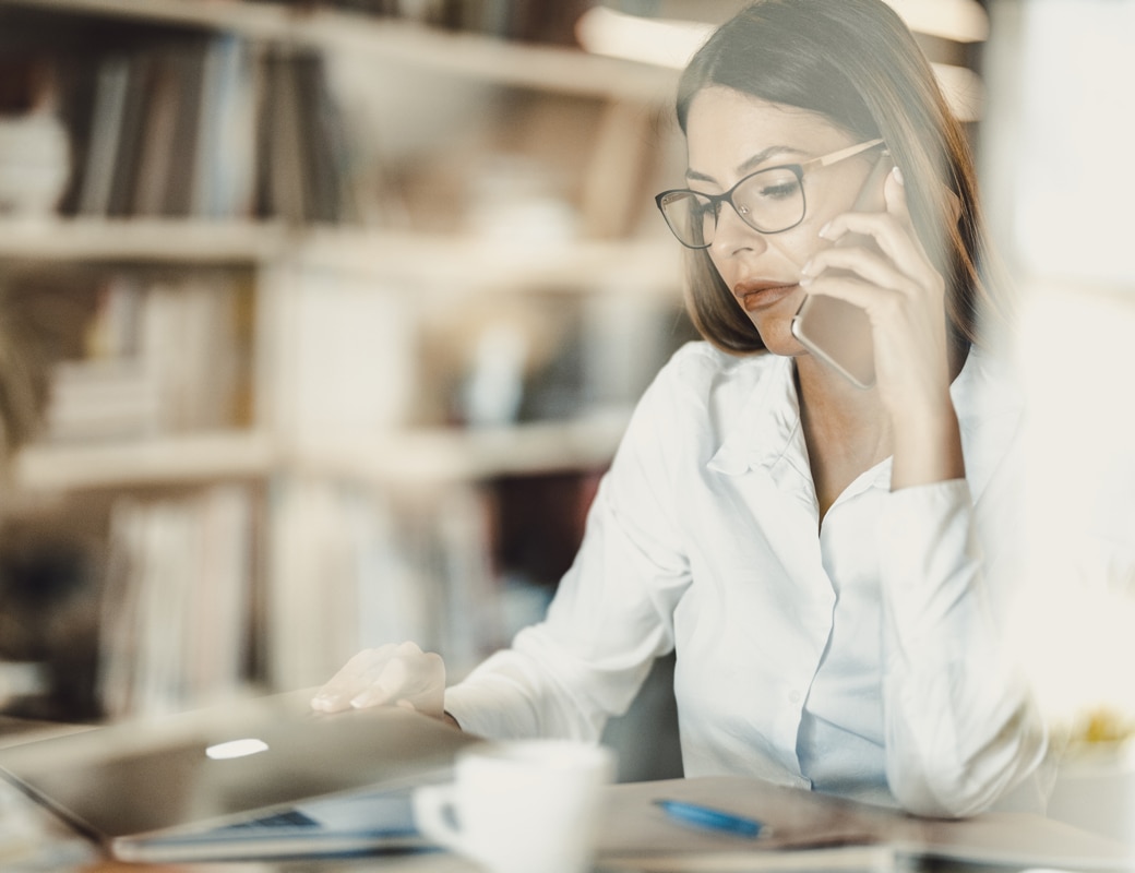 Woman sitting at a desk on the phone