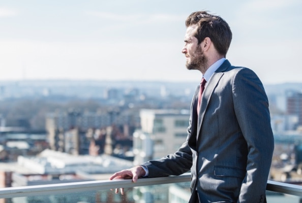 A businessperson looks out at a cityscape.