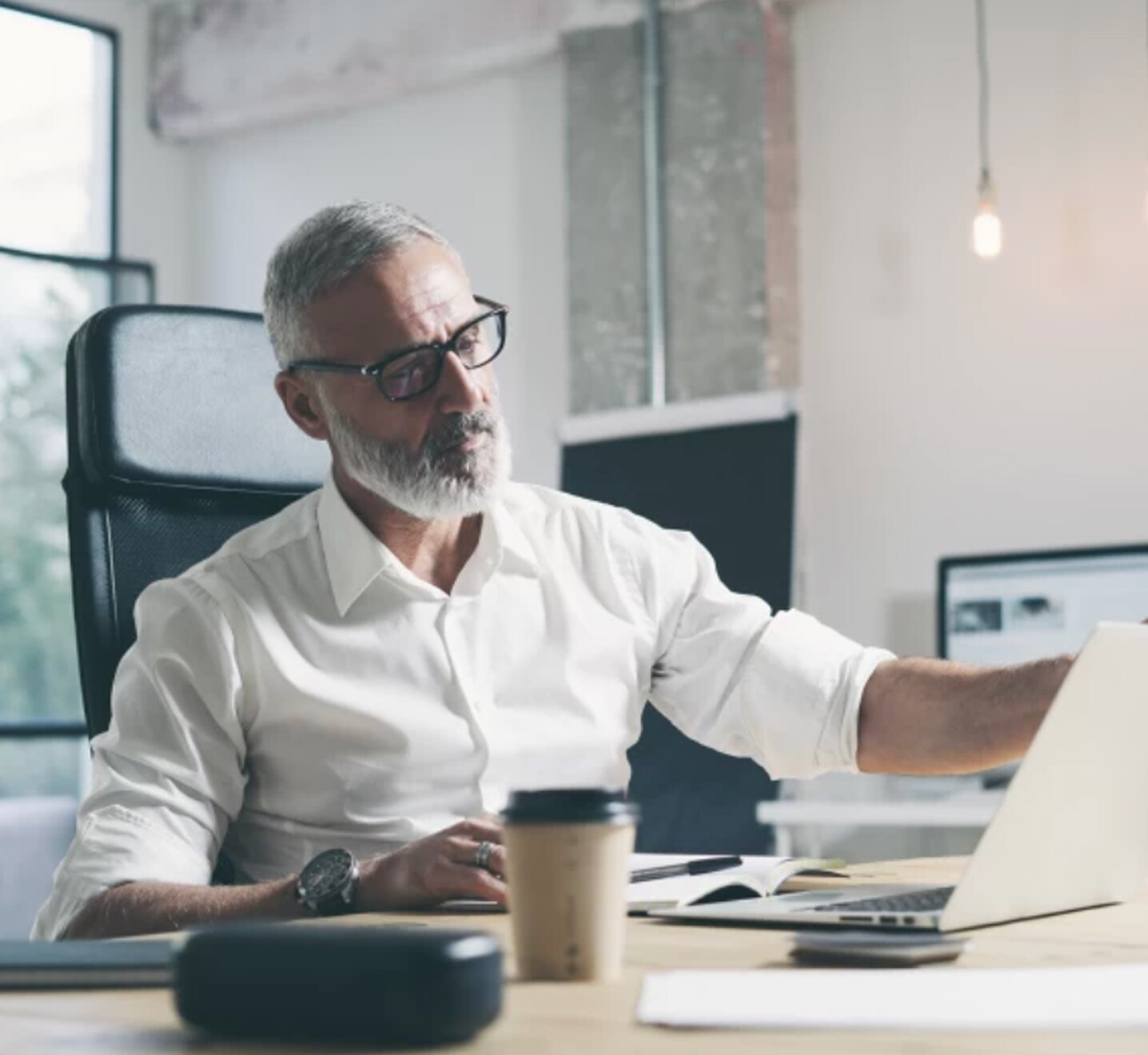 An advisor in a button-down shirt opens his laptop.