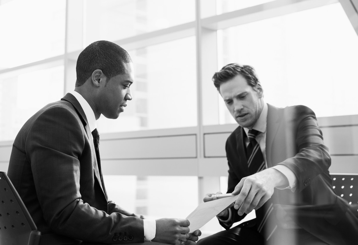 Two men in an office talking about a document
