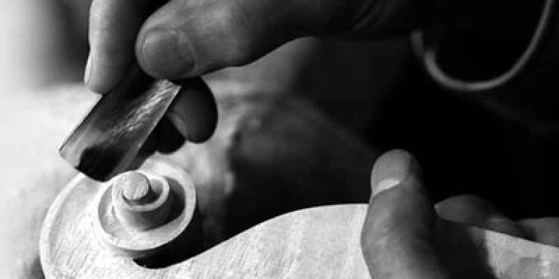 Hands carving wood