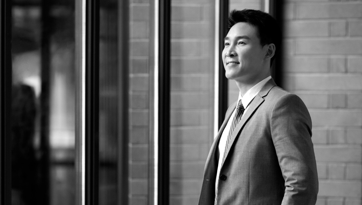 An advisor walks out of a building smiling.