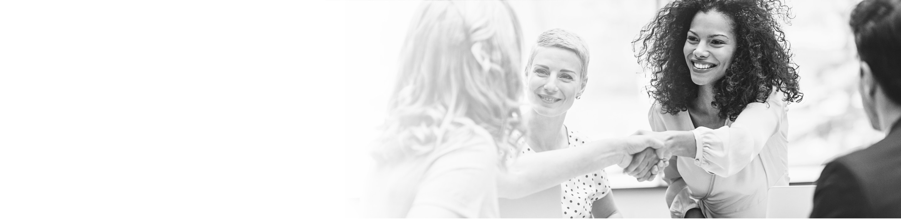 A young professional woman shakes hands with a colleague in a business meeting.
