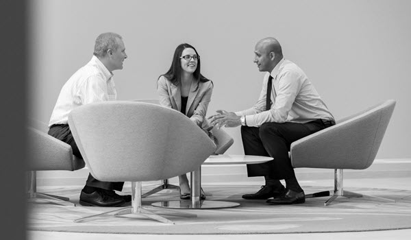 RIA employees sitting in a circle in conversation.