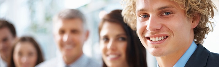 A close-up photo of a smiling male intern.